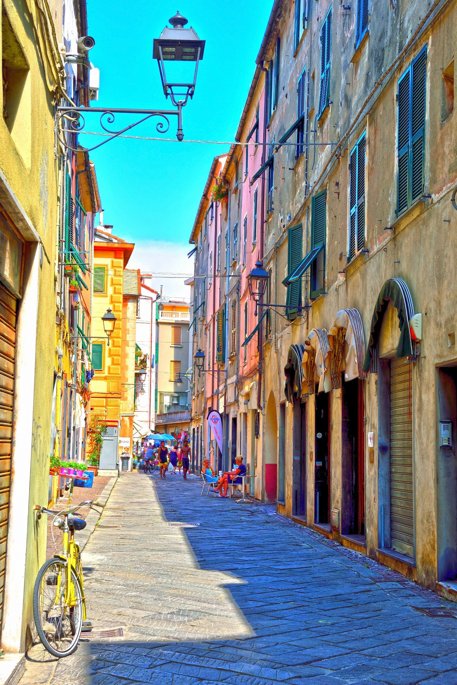 Una strada stretta con una bicicletta parcheggiata a lato.