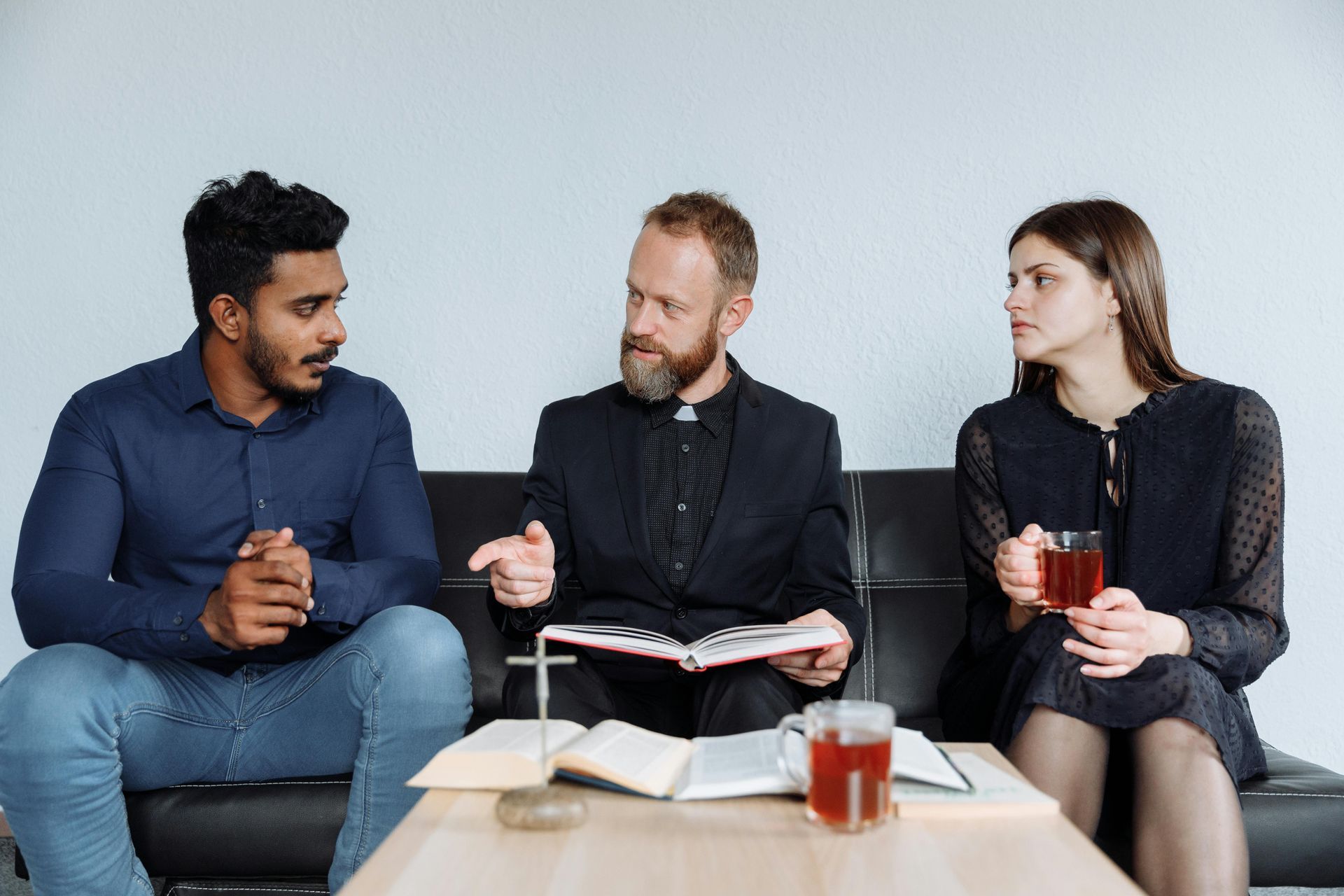 People sit at a modern office table, collaborating and reviewing documents during a meeting in a bright room.