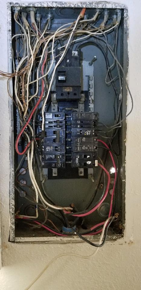A very messy electrical box with a lot of wires coming out of it.