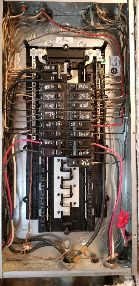 The inside of a electrical panel with a lot of wires coming out of it.
