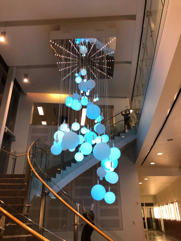 A staircase with a chandelier hanging from the ceiling