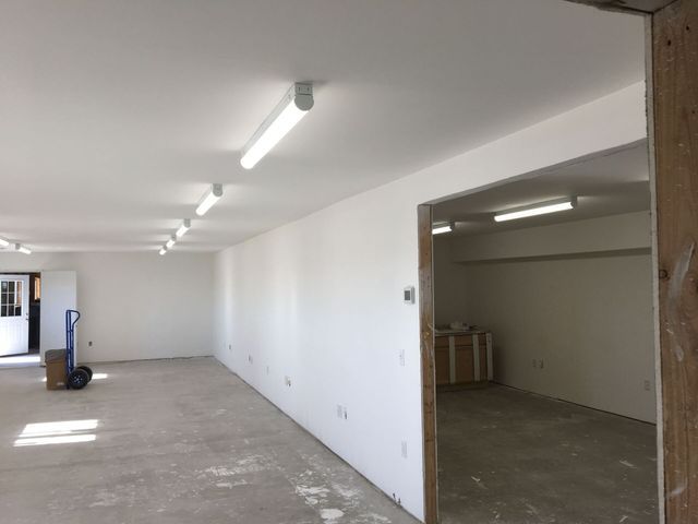 An empty room with white walls and lights on the ceiling