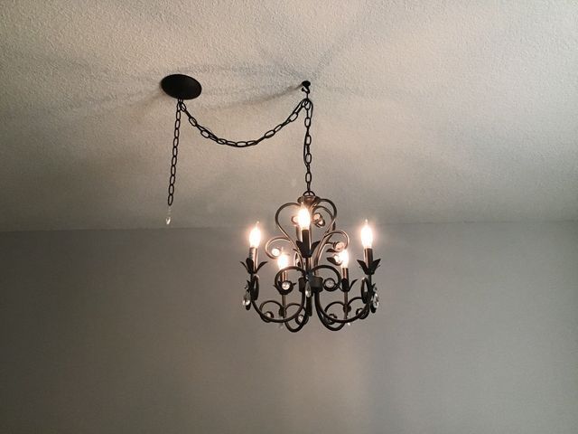 A chandelier is hanging from the ceiling in a room