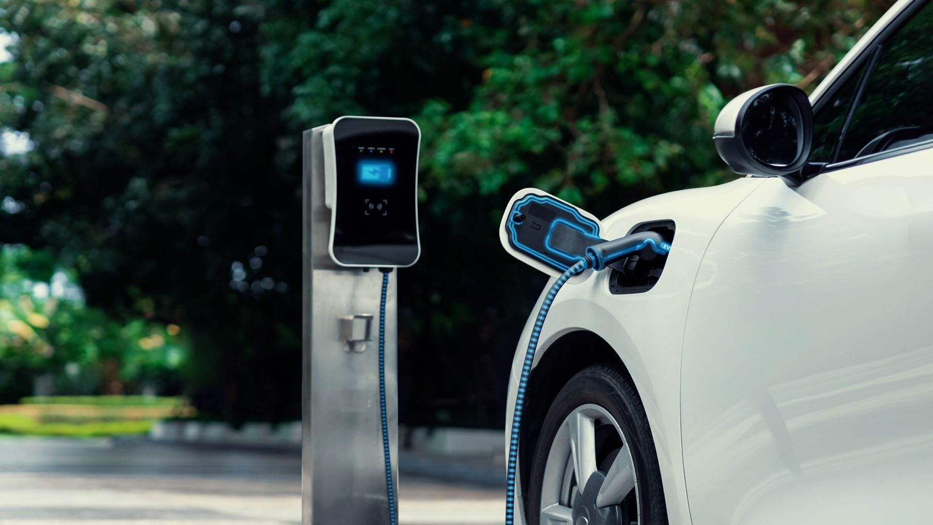 A white electric car is being charged at a charging station.