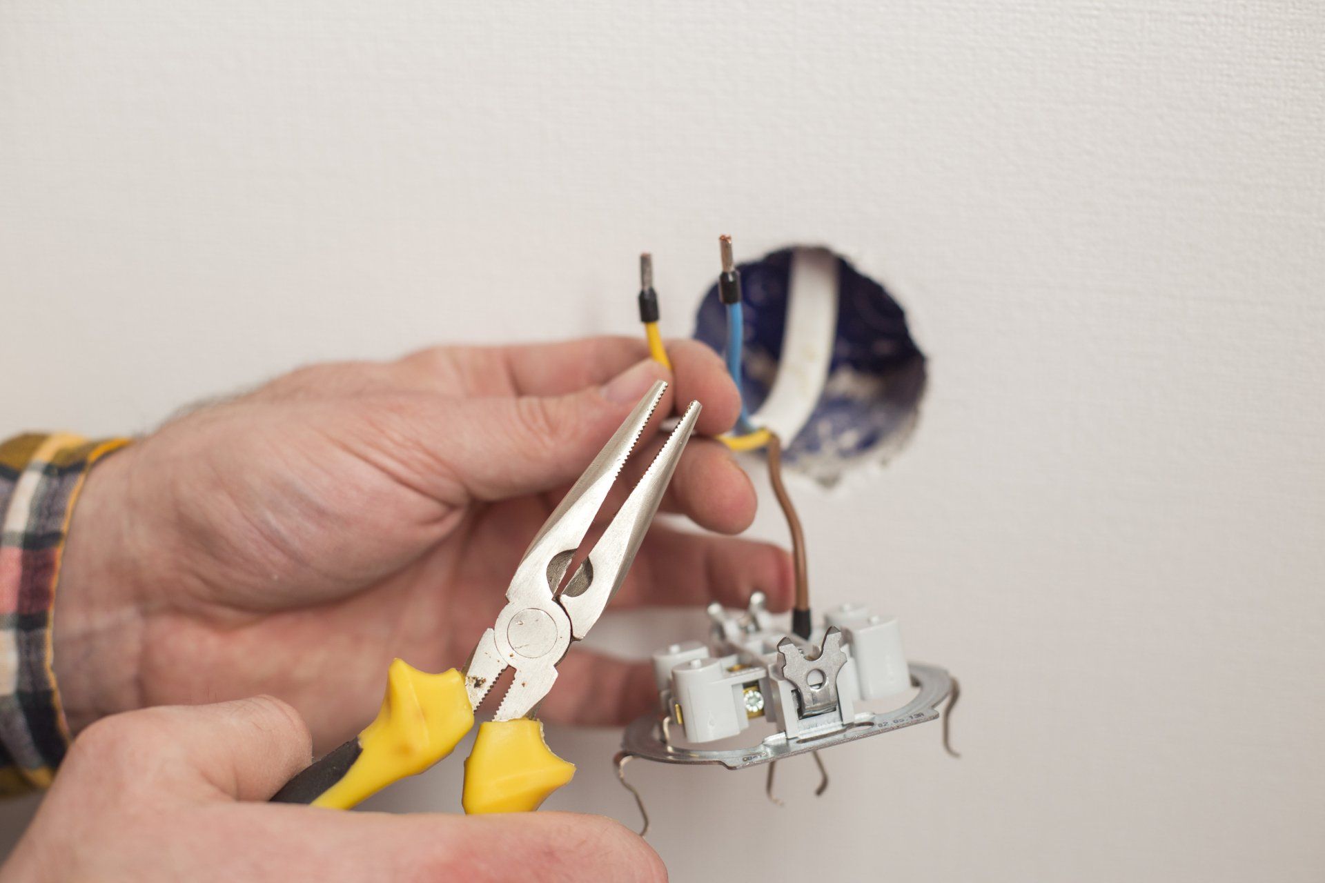 Electrician peeling off insulation from wires