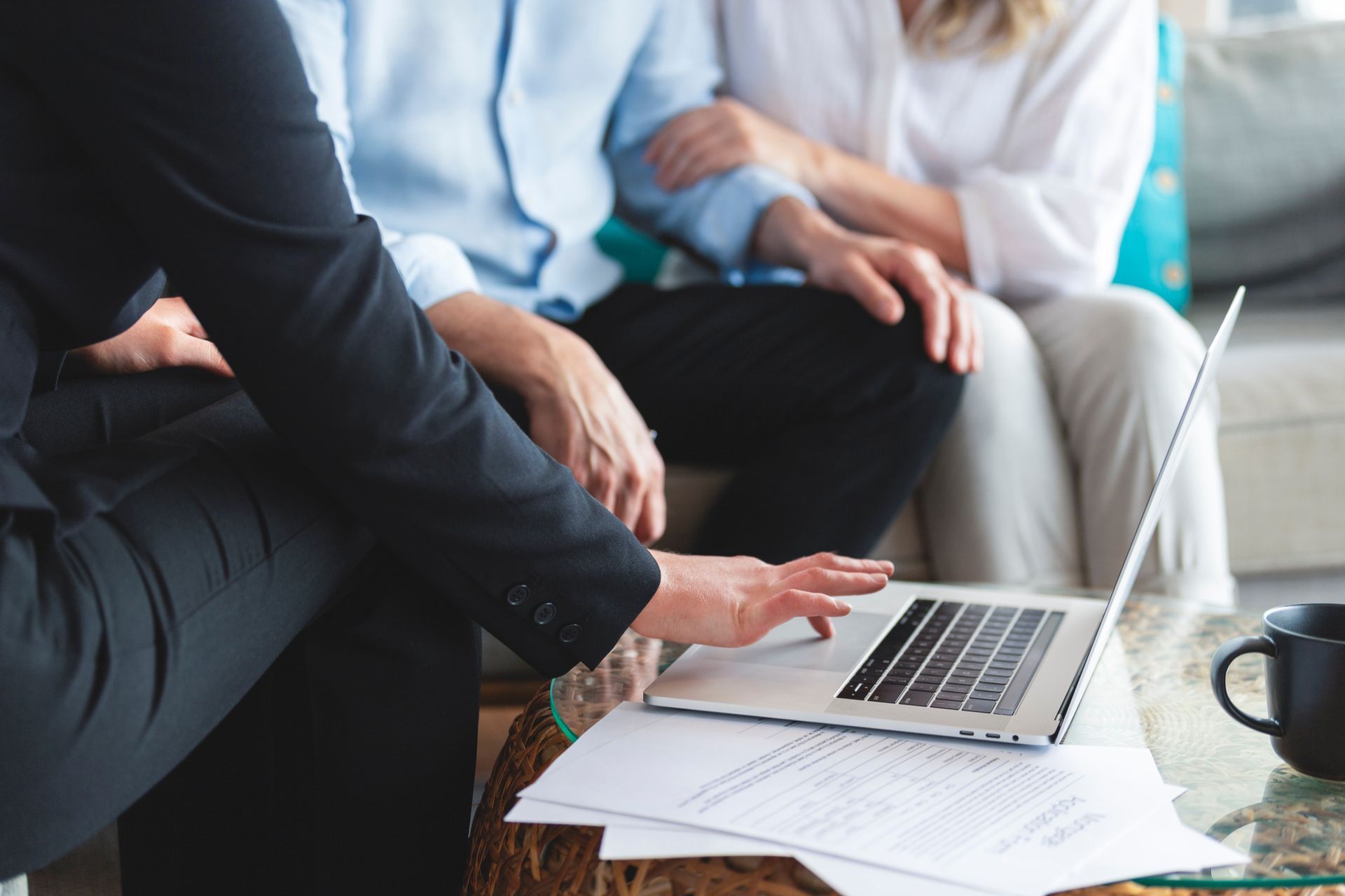 A man and a woman are sitting on a couch looking at a laptop.