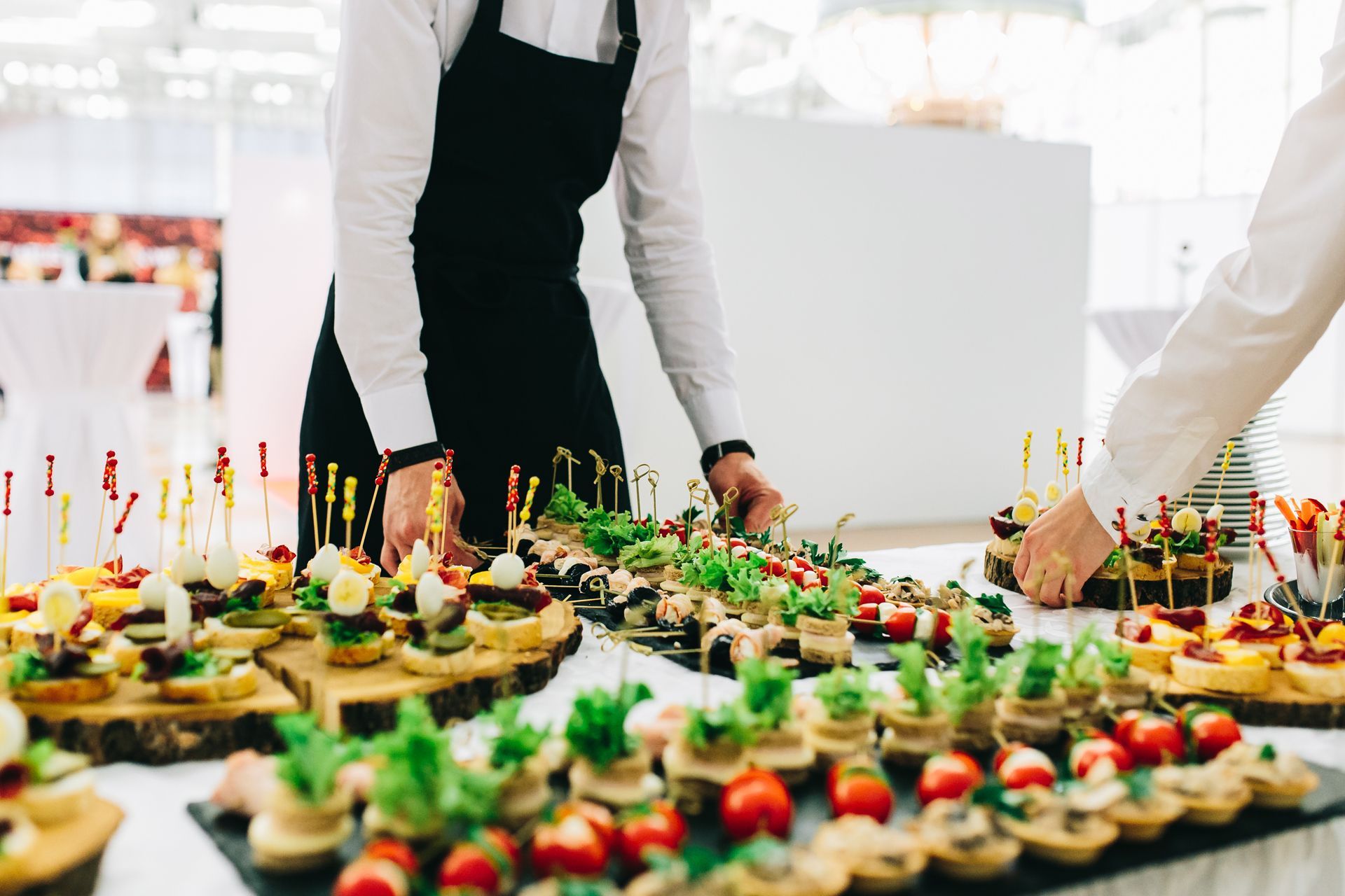 A group of people are standing around a table filled with food.
