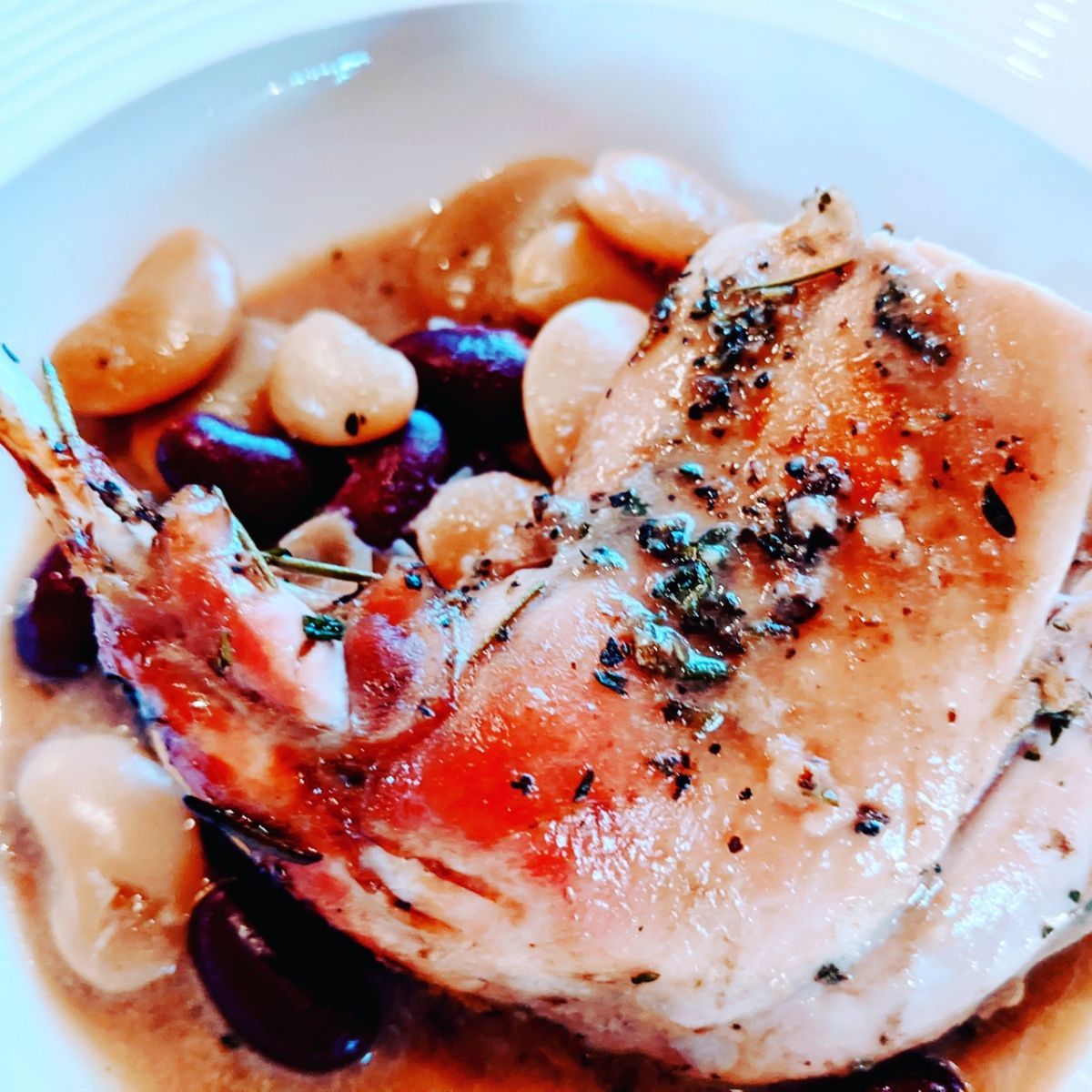 A close up of a plate of food with meat and beans