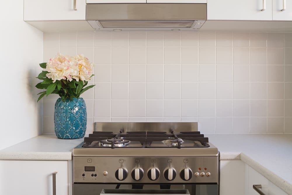 A Stove with A Vase of Flowers on Top of It in A Kitchen — Top End Joinery In Yarrawonga, NT