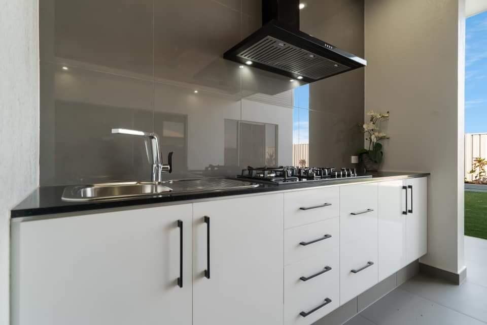 A Kitchen With White Cabinets, Black Counter Tops, a Sink and a Stove — Top End Joinery In Yarrawonga, NT