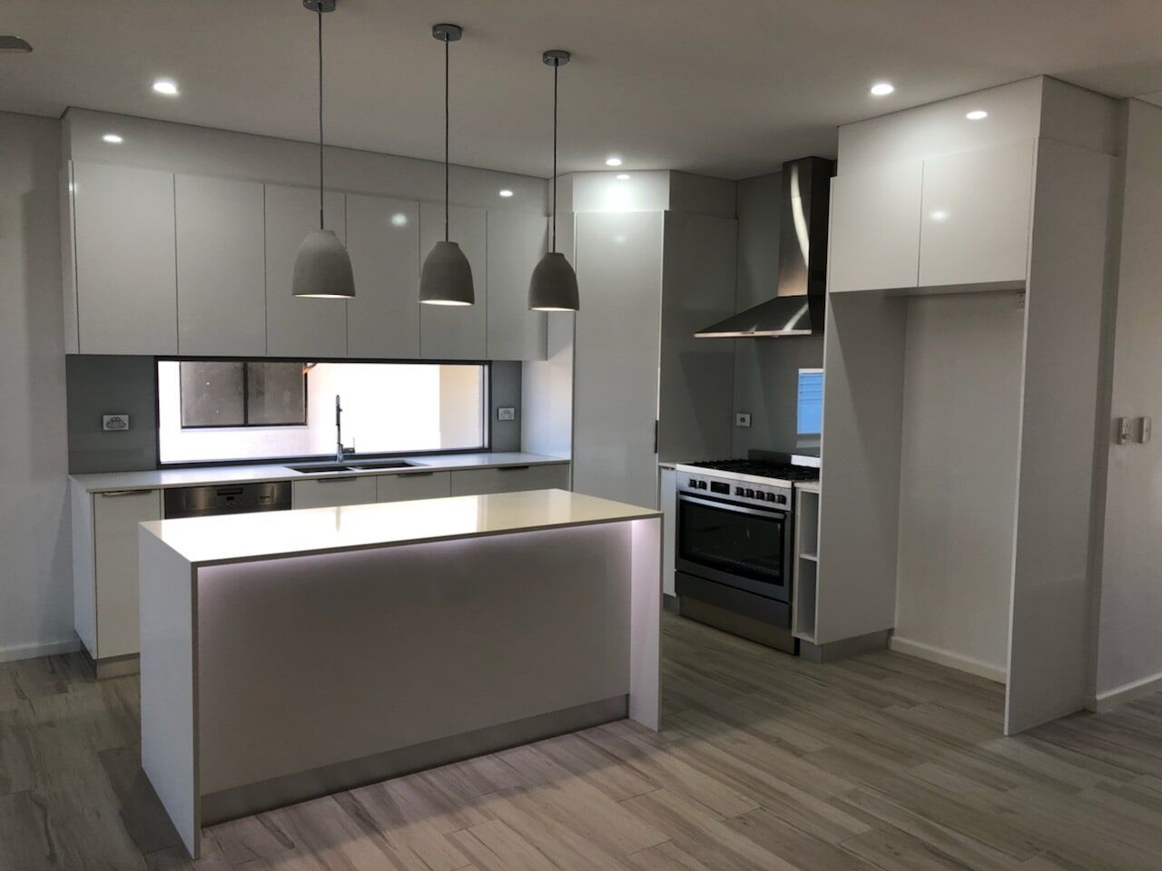 A Kitchen With White Cabinets and a Large Island — Top End Joinery In Yarrawonga, NT