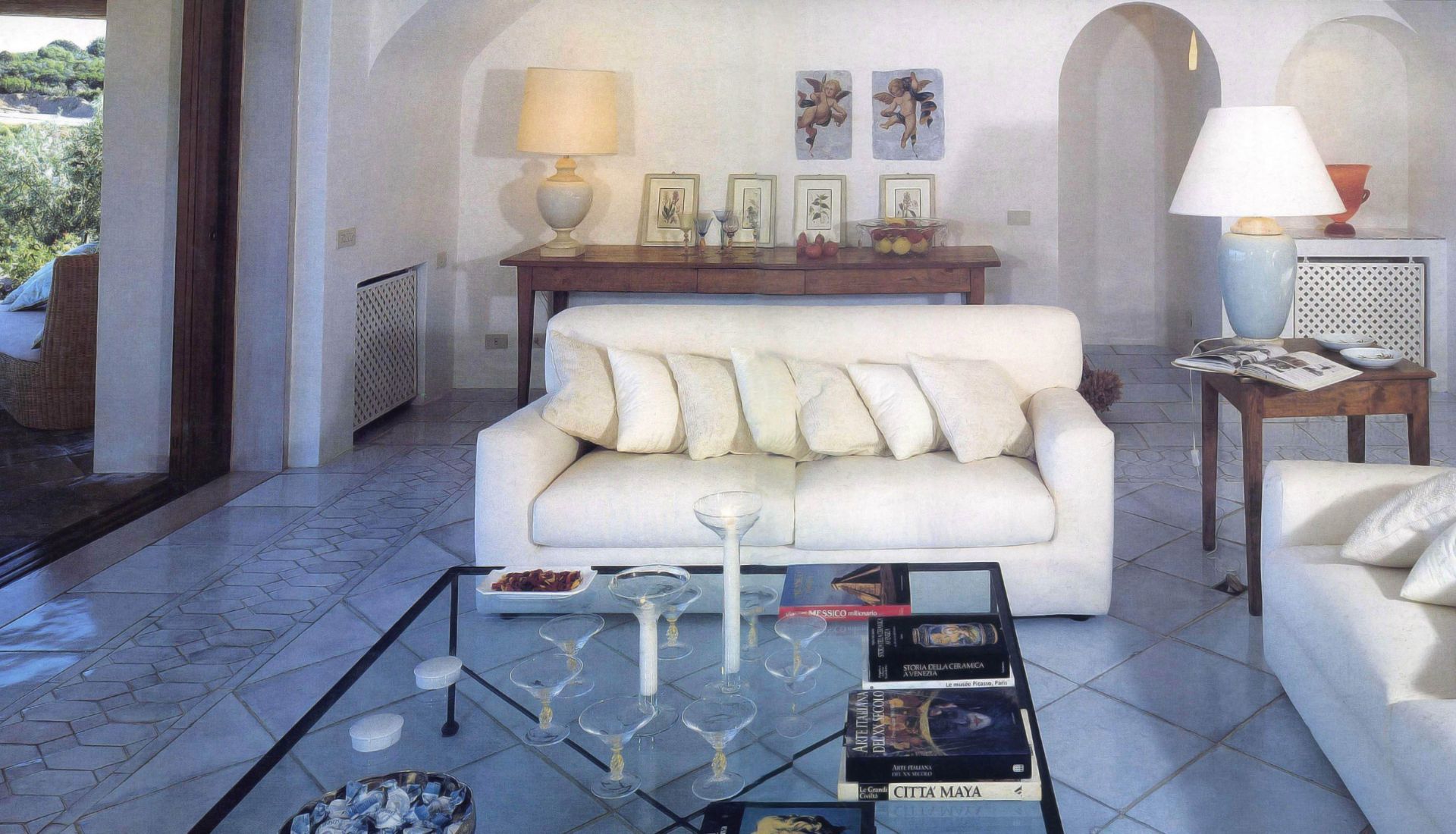 Un soggiorno con un divano bianco e un tavolino in vetro