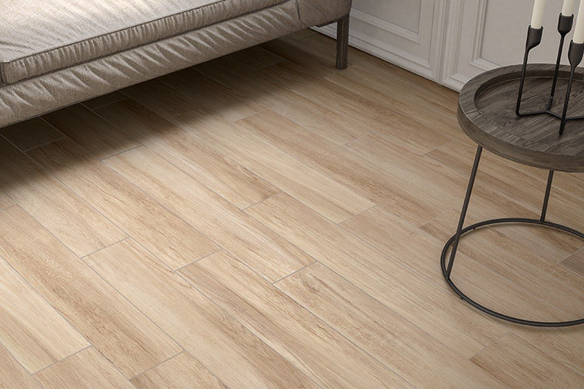 Un soggiorno con pavimento in legno, un divano e un tavolo.