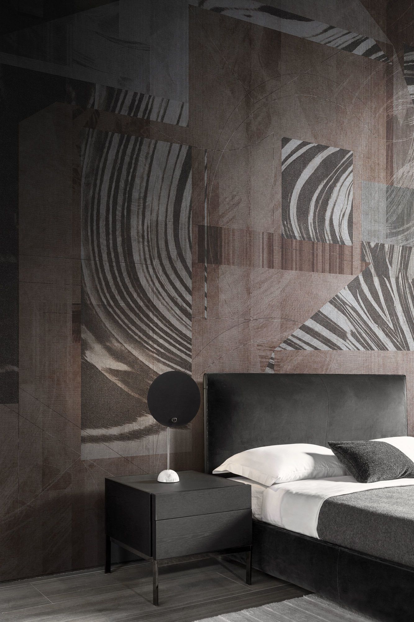 Una camera da letto con un letto, un comodino, una lampada e un grande murale.