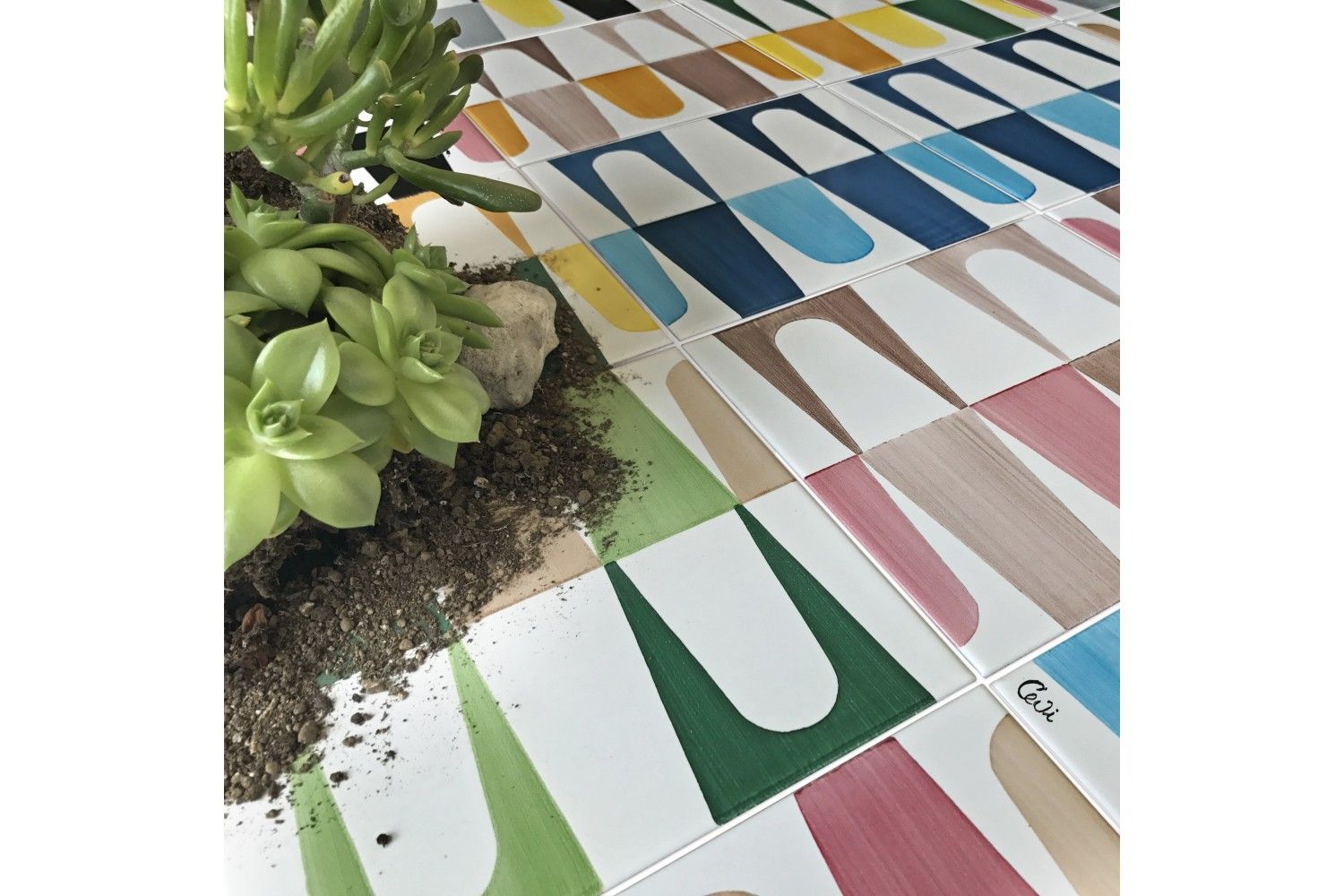 Un pavimento piastrellato colorato con una pianta al centro