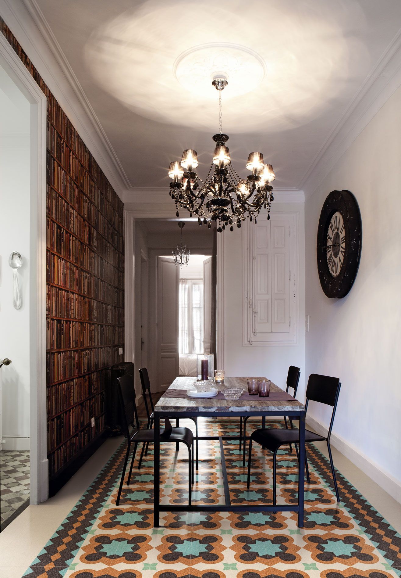 Una sala da pranzo con tavolo, sedie e lampadario