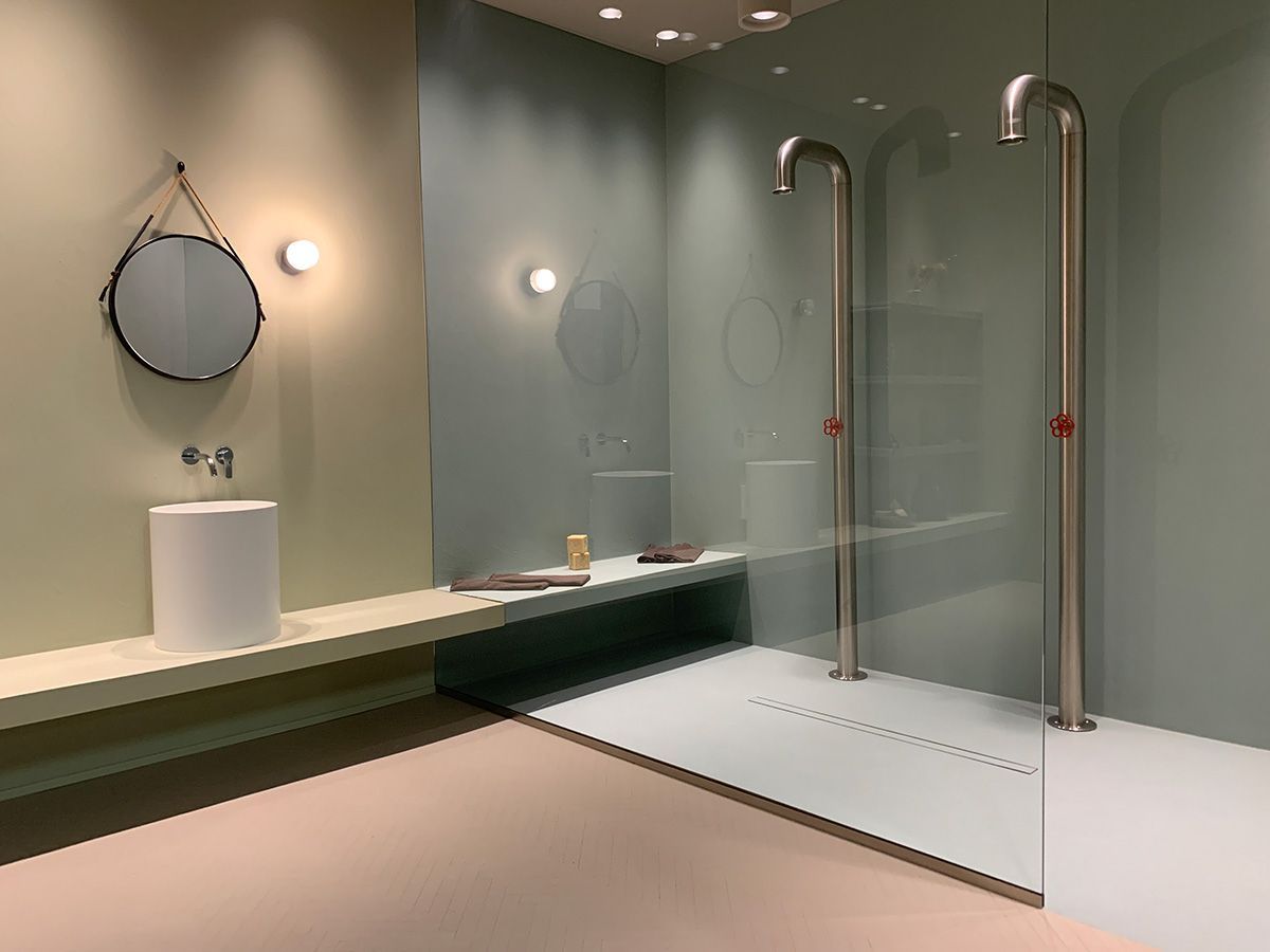 Un bagno con due docce, un lavandino e uno specchio.