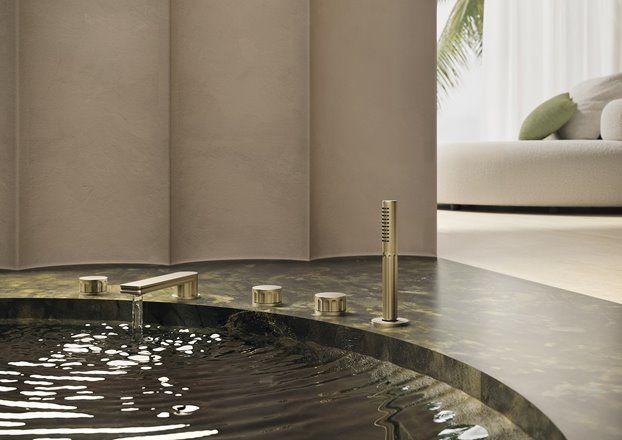 Un bagno con vasca e un divano sullo sfondo.