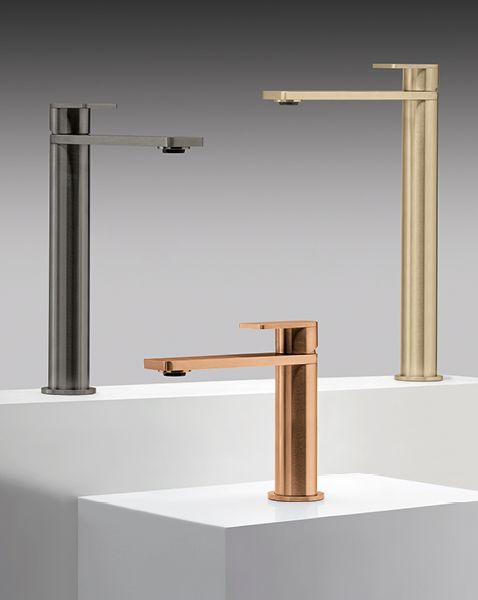 Tre rubinetti sono posizionati sopra un bancone bianco.