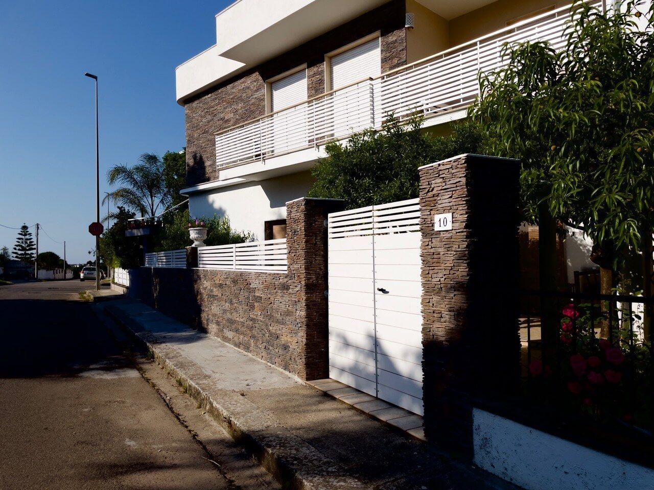 Una casa con un cancello bianco davanti