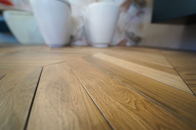 Un primo piano di un tavolo di legno con candele sullo sfondo.