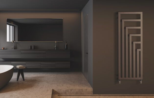 Un bagno con vasca, lavandino, specchio e portasciugamani.