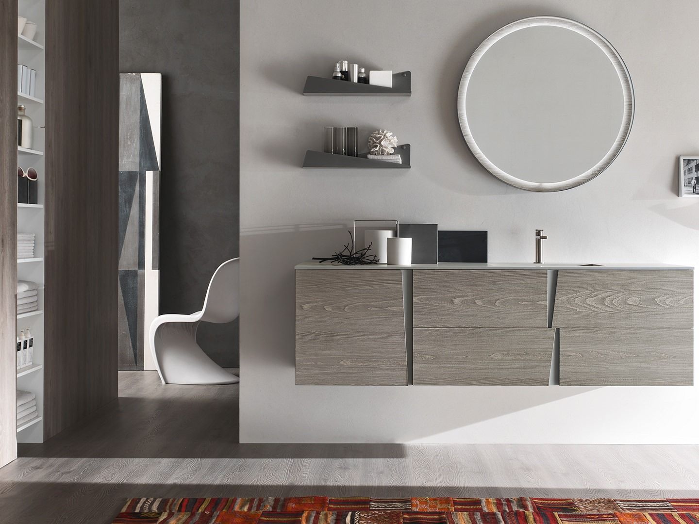 Un bagno con un lavandino, uno specchio e degli scaffali