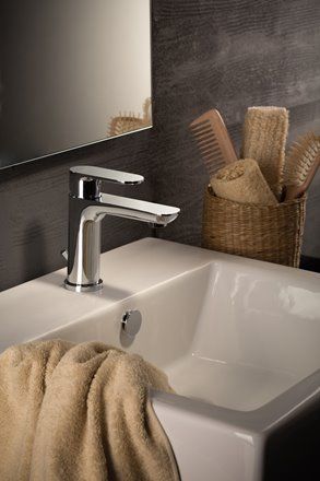 Un lavandino del bagno con un asciugamano appeso sopra e un rubinetto.