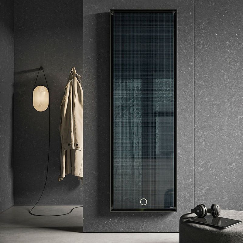 Un cappotto è appeso al muro accanto a uno specchio.