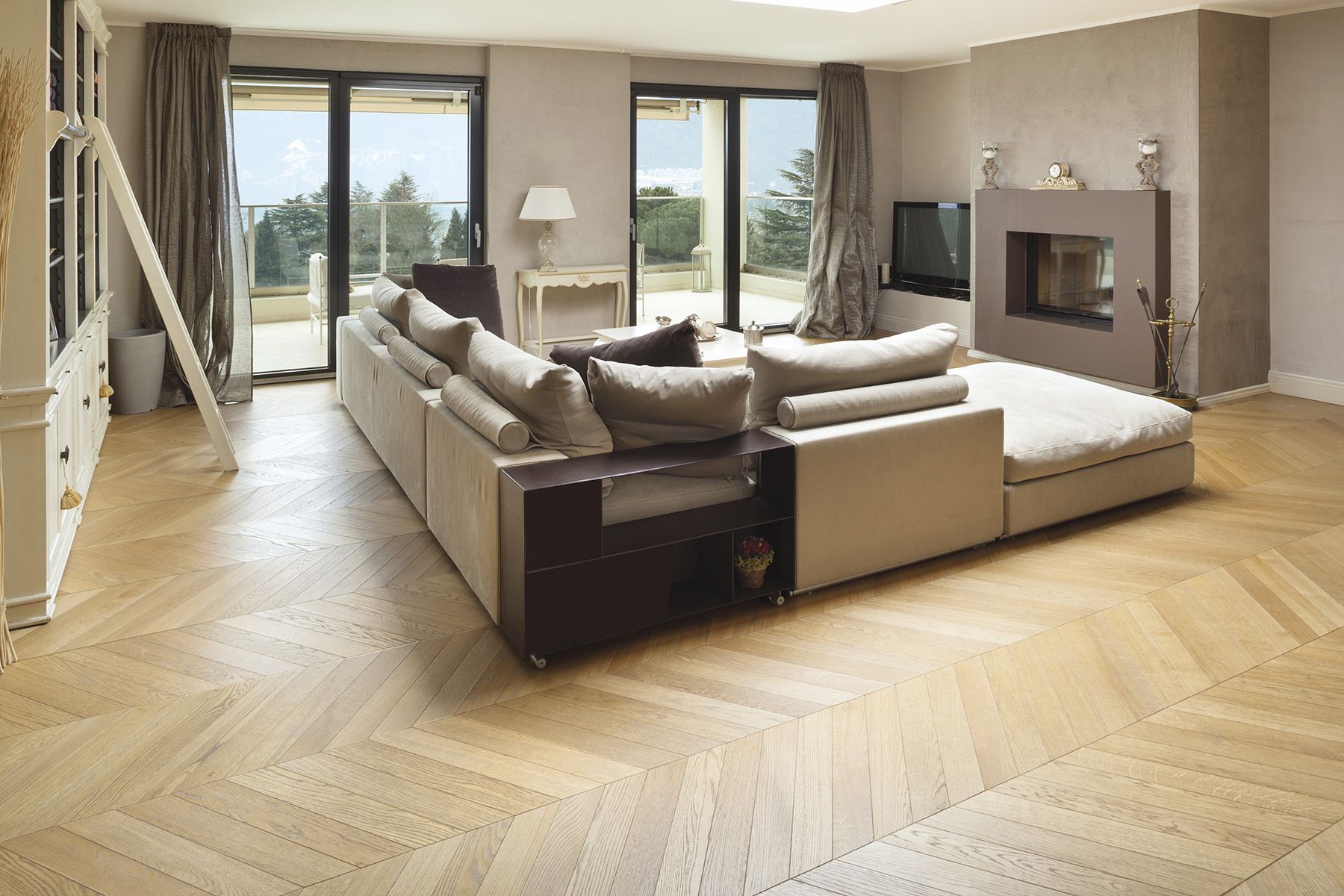 Un soggiorno con divano, camino, televisione e porte scorrevoli in vetro.