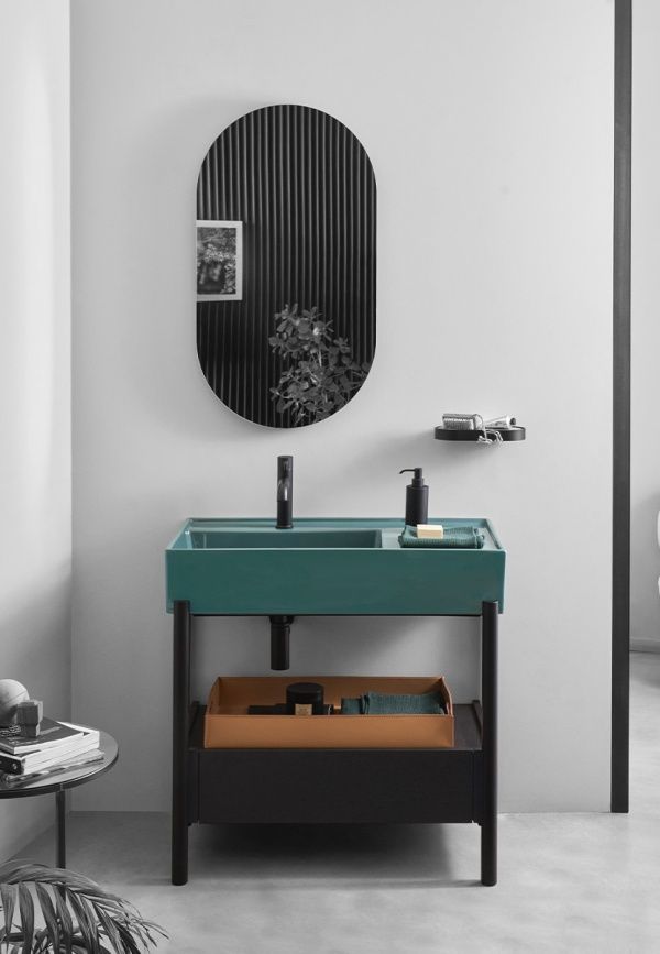 Un bagno con un lavandino verde e uno specchio.