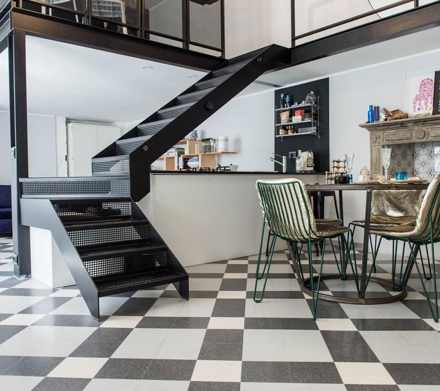 Un pavimento a scacchi bianchi e neri in una stanza con scale