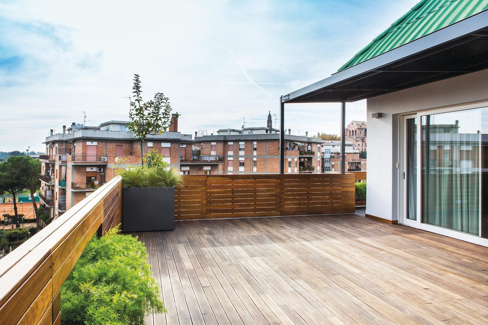 Una terrazza sul tetto con un tetto verde e una ringhiera in legno