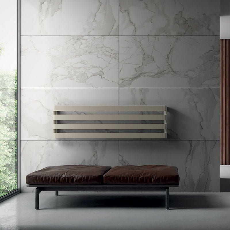 Una panchina è seduta di fronte a un muro di marmo accanto a una finestra.