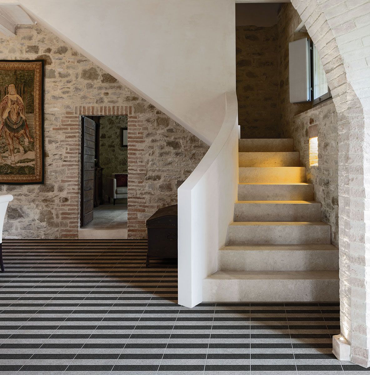 Una scala in un edificio in pietra con pavimento a strisce