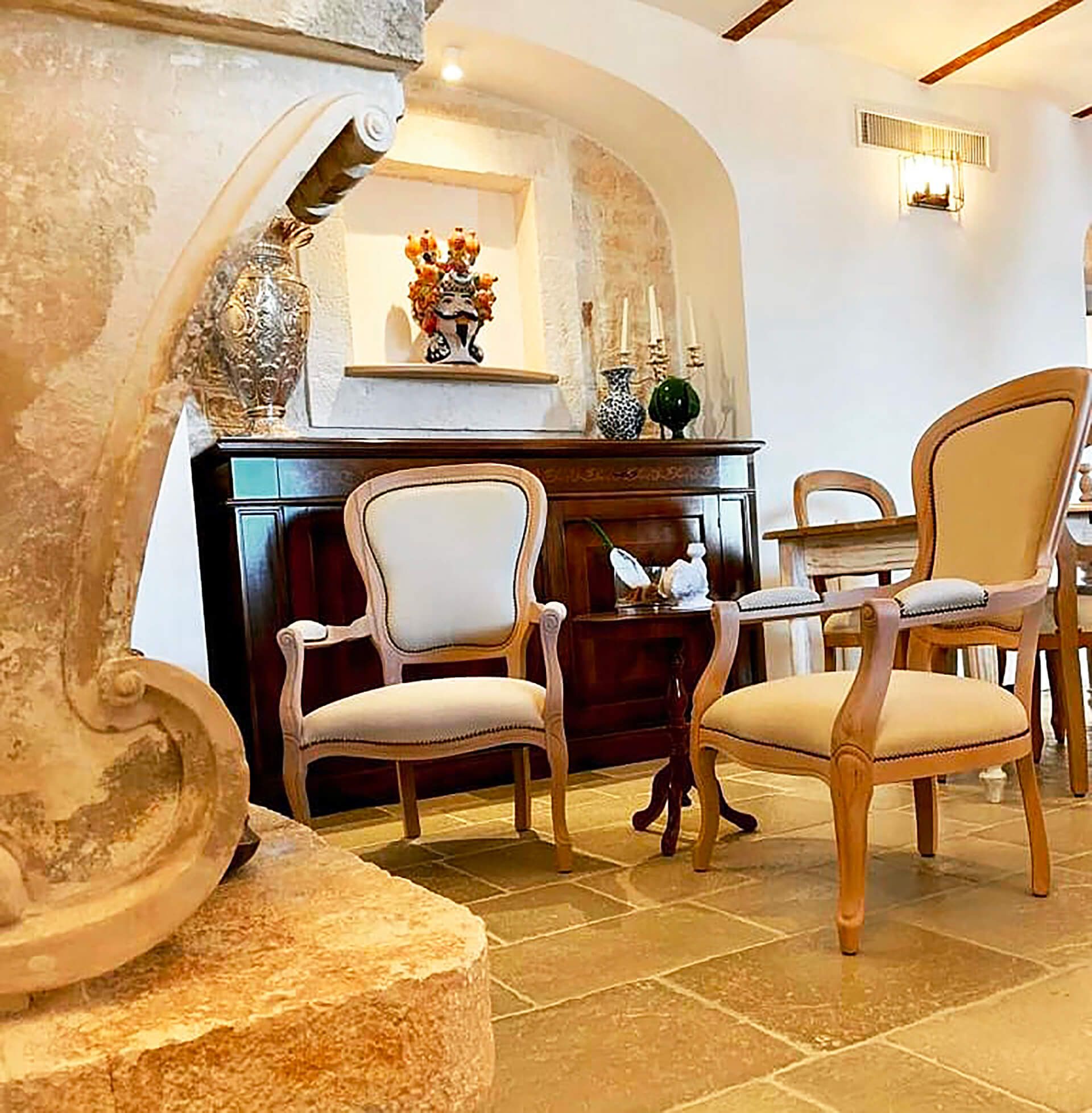 Un soggiorno con sedie tavoli e un vaso sul muro