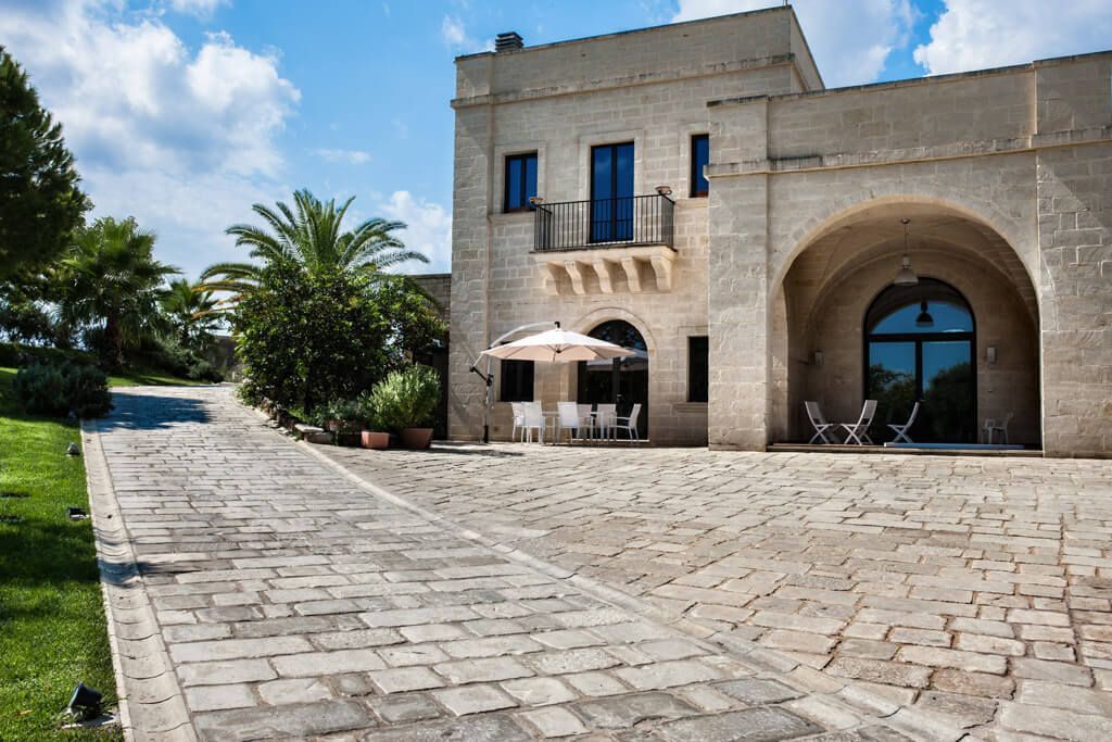 Un grande edificio in pietra con un vialetto in mattoni che vi conduce