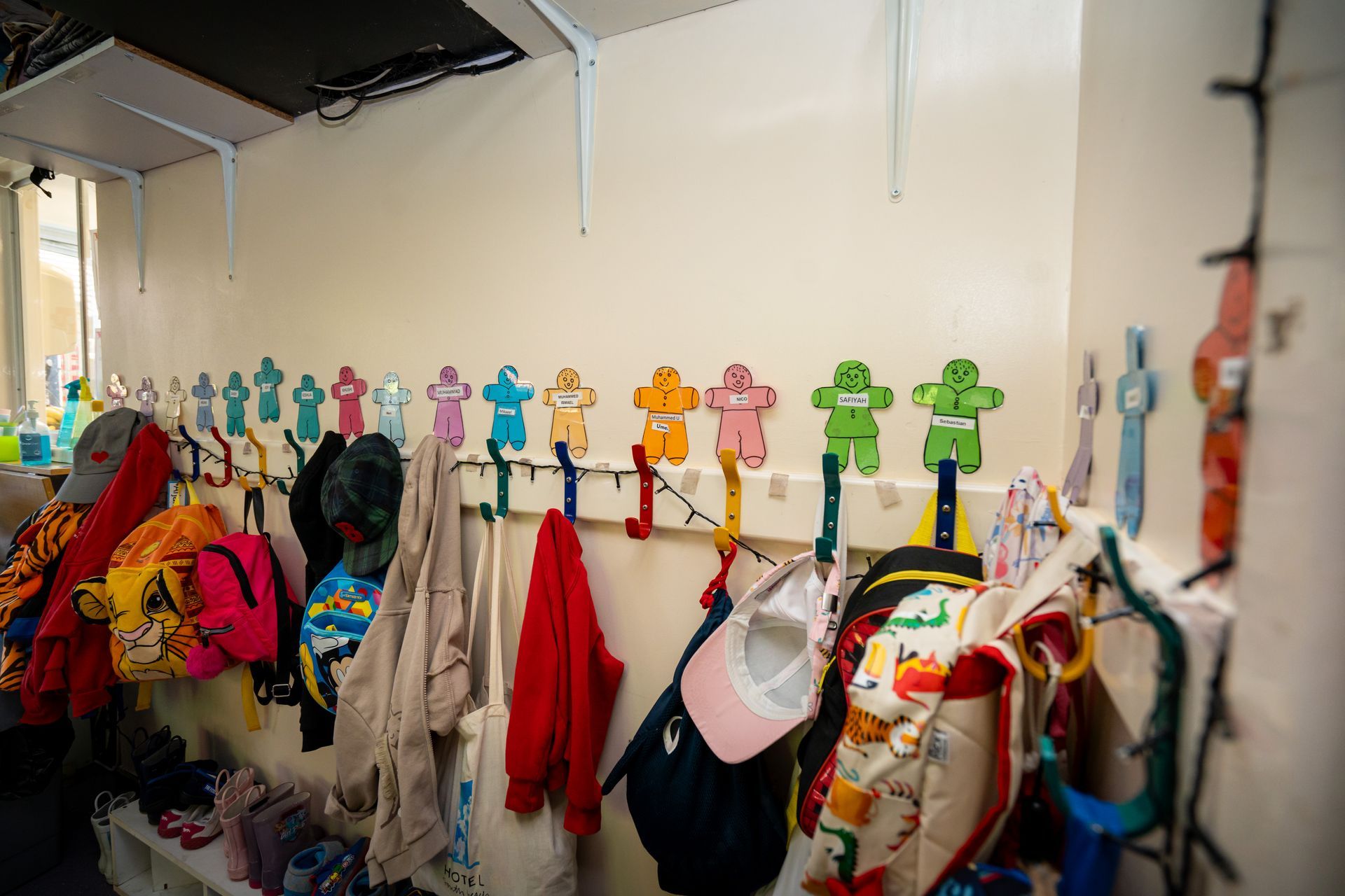 A row of hooks on a wall with clothes hanging on them. Gingerbread