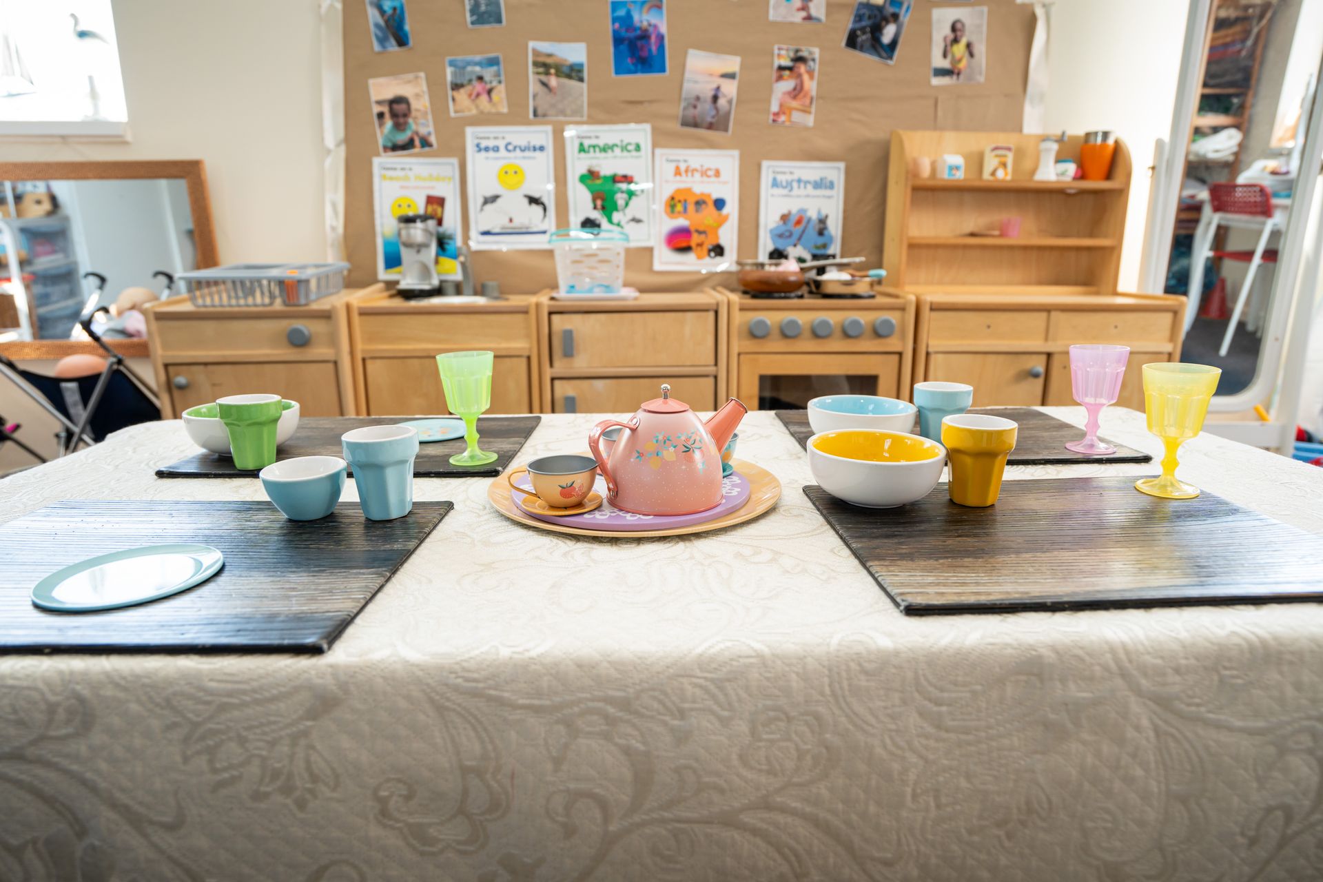 A table with a teapot , cups , and glasses on it. Gingerbread