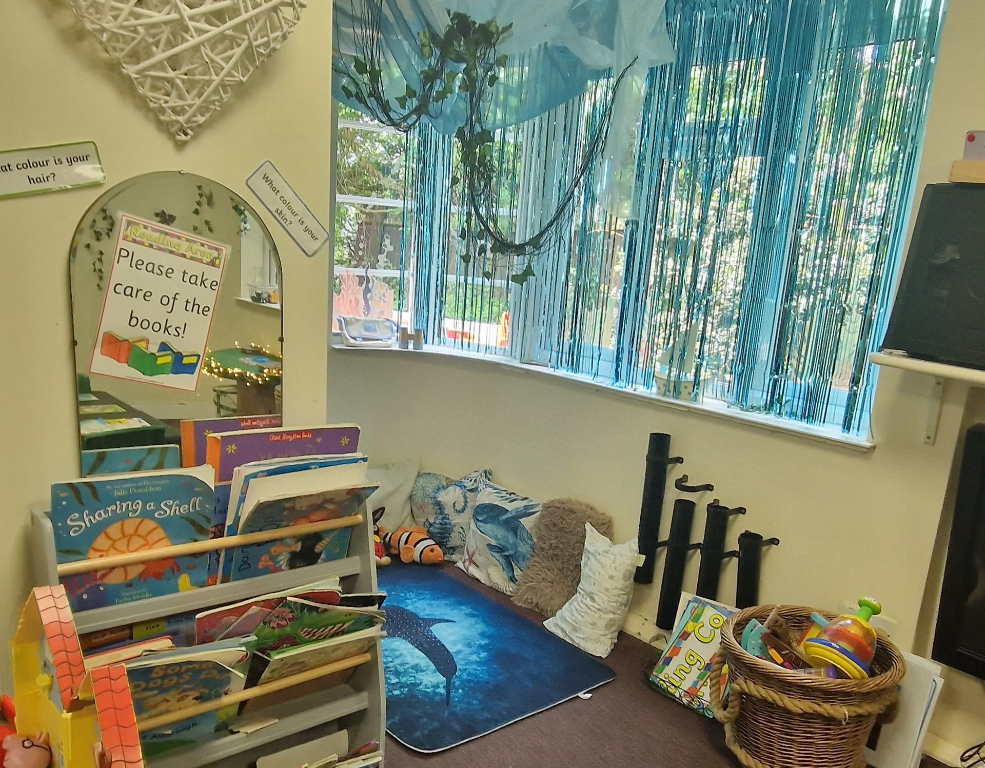 A room with a bookshelf filled with books and toys. Gingerbread