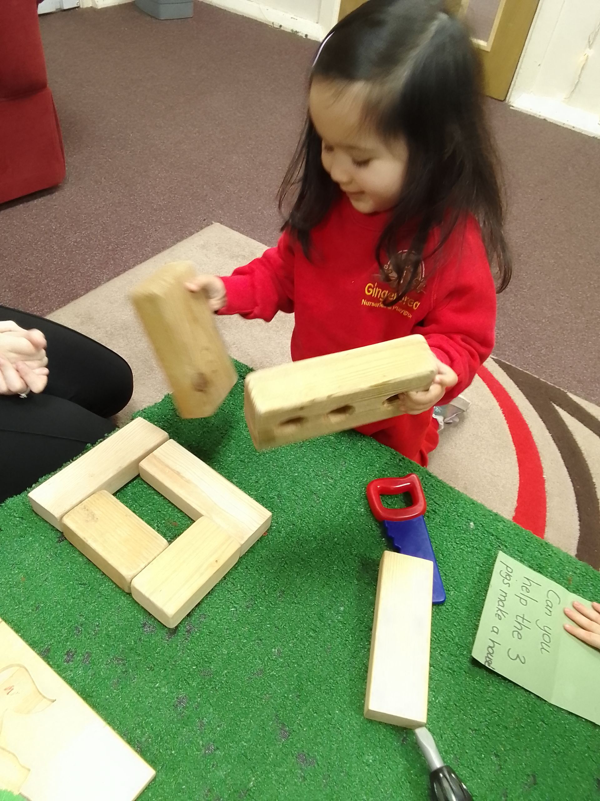 A little girl is playing with wooden blocks on a table Gingerbread