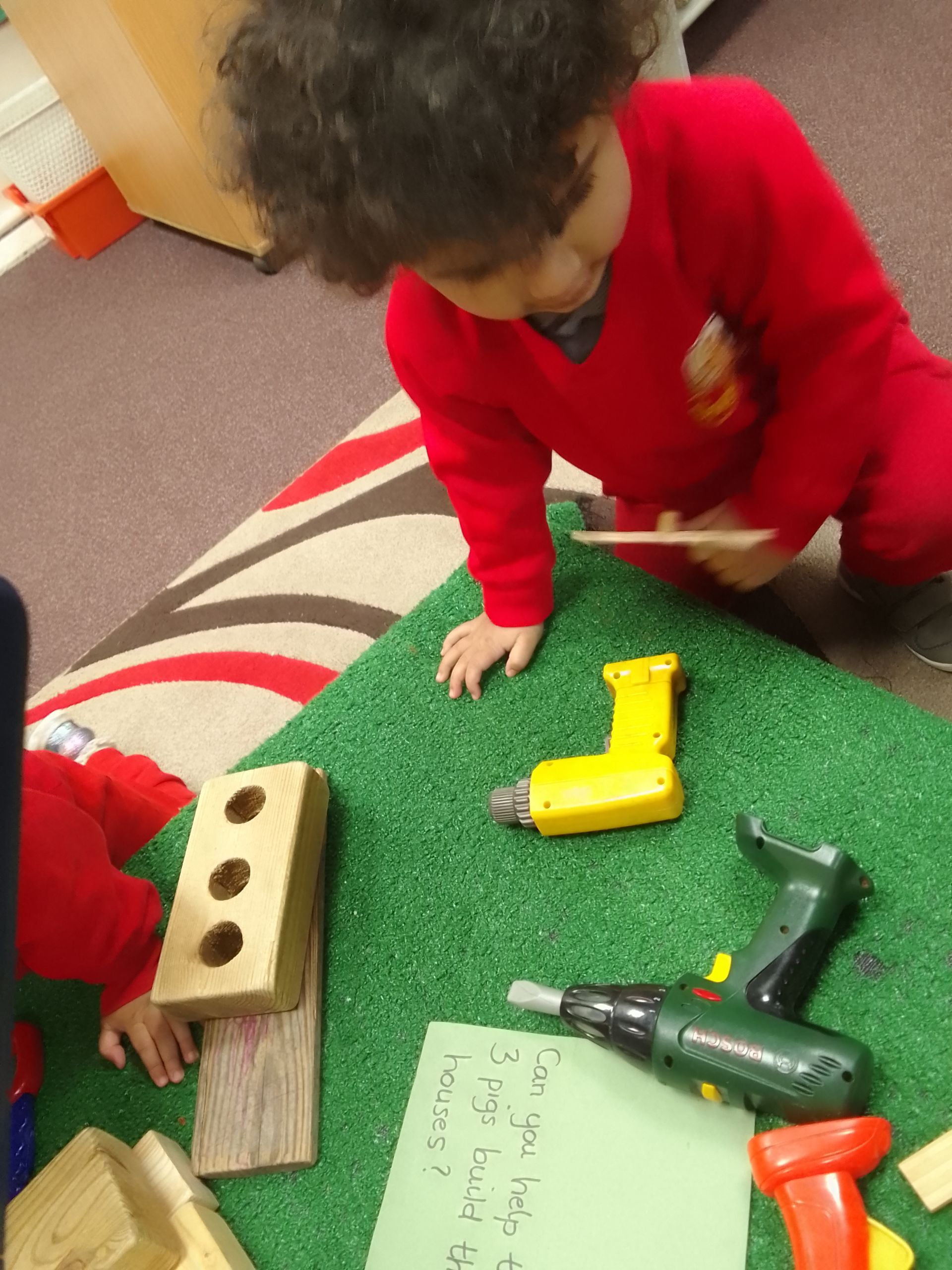 A little boy in a red shirt is playing with toy tools Gingerbread