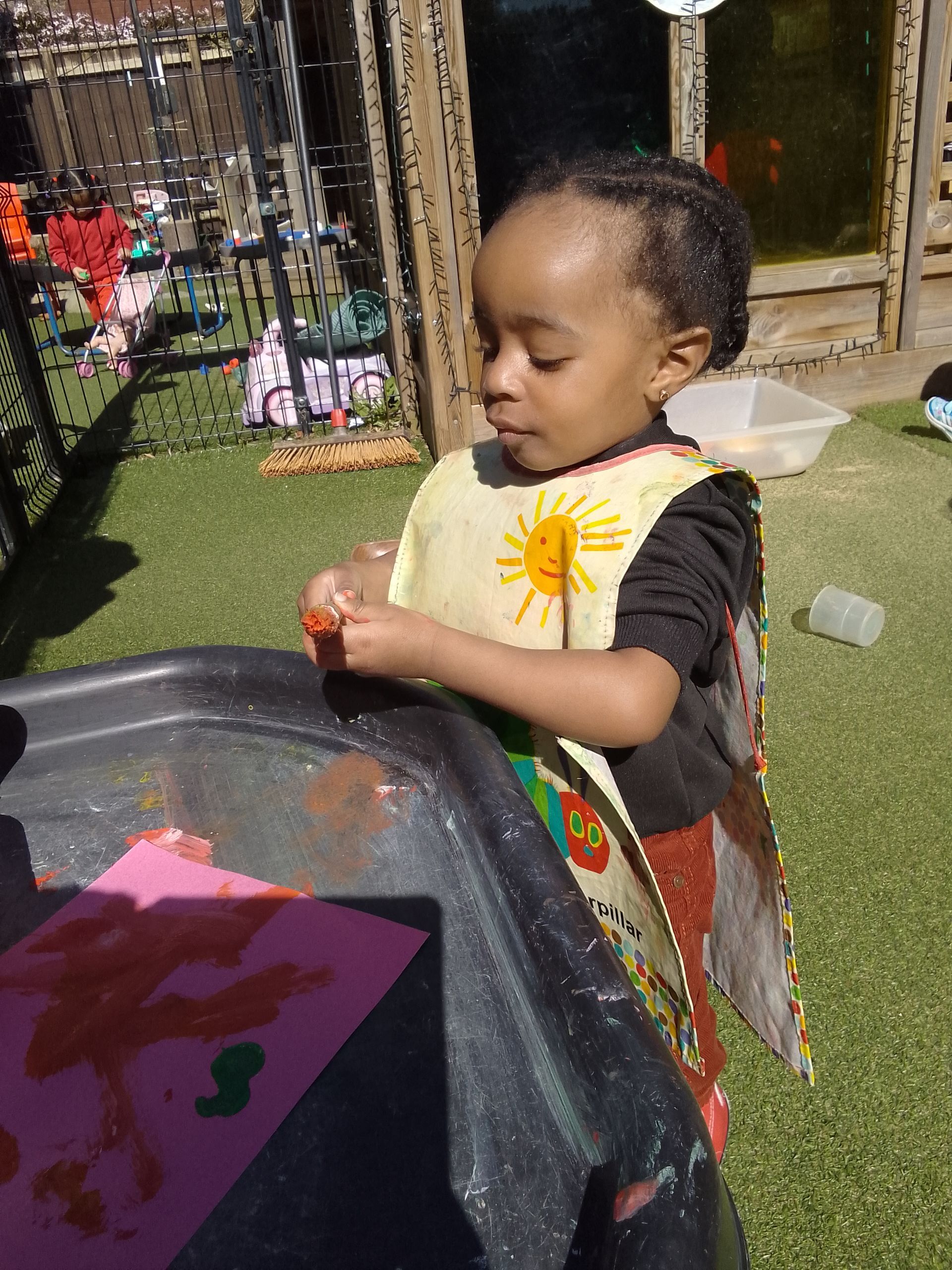 A little girl in a fairy costume is playing with a bucket of water. Gingerbread