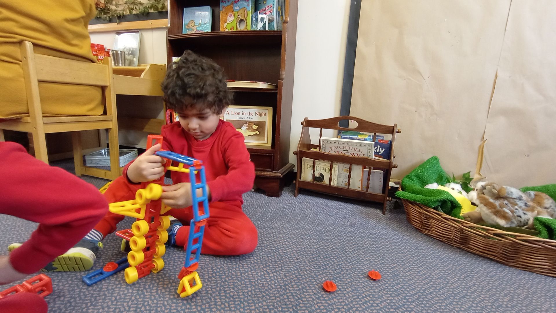 A child is sitting on the floor playing with toys Gingerbread