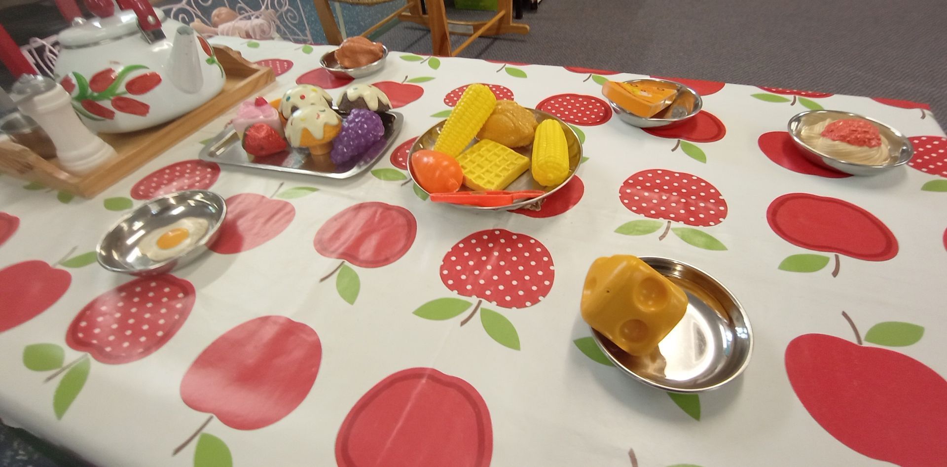 A table with plates of food and a bowl of fruit on it. Gingerbread