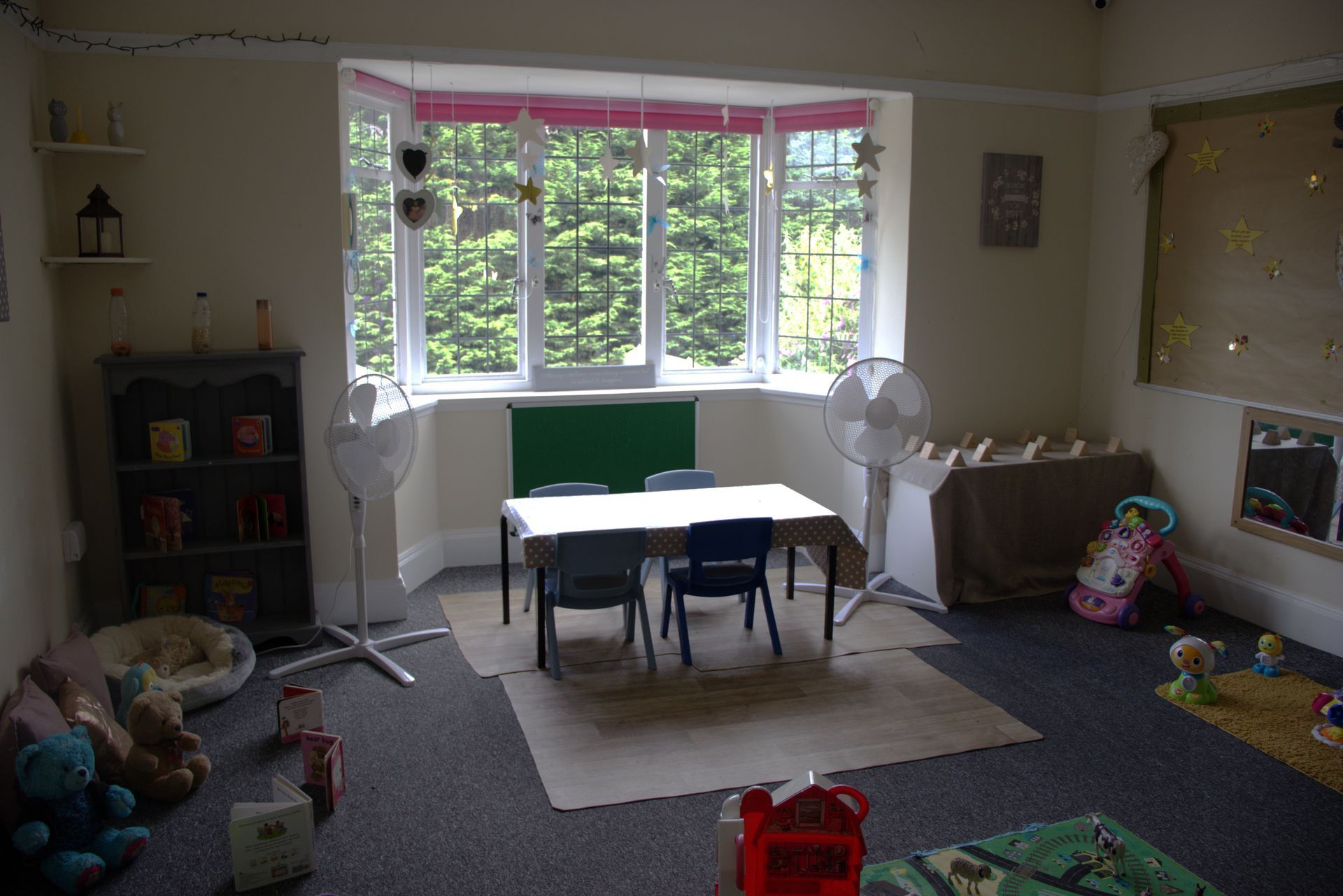 A room with a table and chairs in it and a large window. Gingerbread