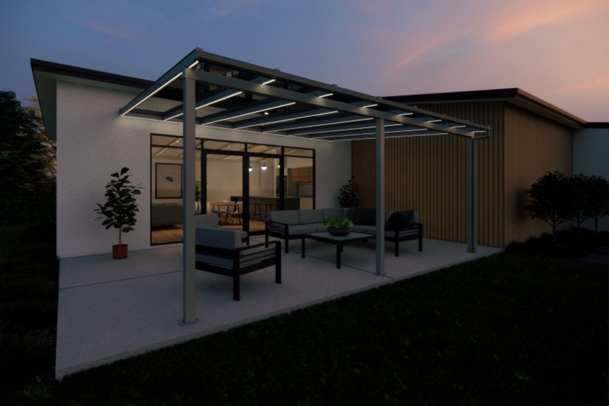 A patio with a pergola and a couch and chairs in front of a house.