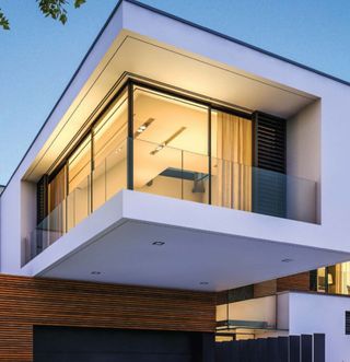 A modern house with a balcony and lots of windows