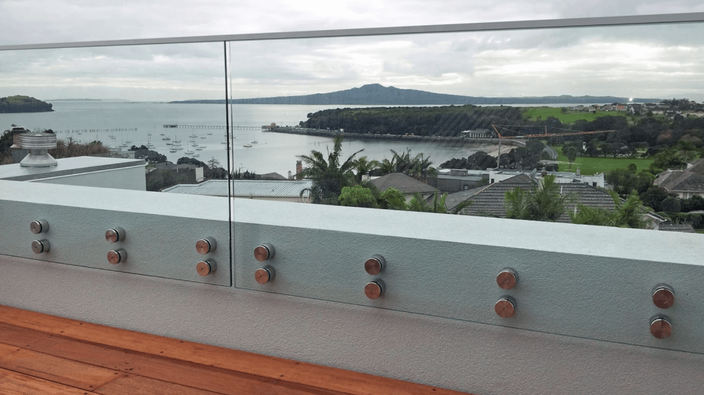 A view of the ocean from a balcony with a glass railing.