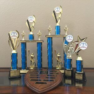 A group of blue trophies are sitting on top of a wooden table.